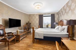 a hotel room with a large bed and a television at Best Western Vetlanda Stadshotell in Vetlanda