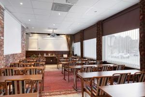une salle de classe vide avec des tables et des chaises en bois dans l'établissement Best Western Vetlanda Stadshotell, à Vetlanda