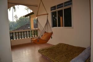 um quarto com uma rede de descanso na varanda em Vailankanni Guesthouse em Morjim