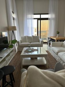 ein Wohnzimmer mit weißen Sofas und einem Couchtisch in der Unterkunft The Beach House in Muscat
