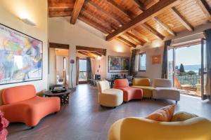 una sala de estar con ventanas y muebles de color naranja y blanco. en Casa Peler al Benaco - Style, Lake view & Pool en Toscolano Maderno