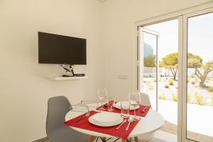 uma sala de jantar com uma mesa vermelha e copos de vinho em O PINHAL DO AVÔ em Almancil