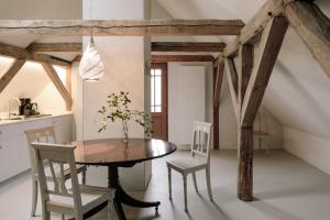 Apartment Alte Schmiede في Saal: مطبخ وغرفة طعام مع طاولة وكراسي خشبية