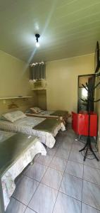 Habitación con 2 camas y espejo. en Hotel Joman Goiânia, en Goiânia