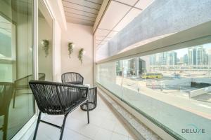 a chair on a balcony with a view of a city at Harmonious 1BR at Al Shera Tower JLT by Deluxe Holiday Homes in Dubai