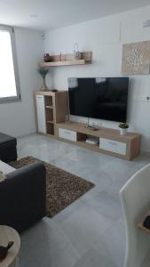 Una sala de estar con un televisor de pantalla plana grande. en Casa Palba, en Conil de la Frontera