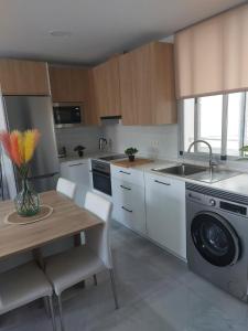 cocina con mesa y lavadora en Casa Palba, en Conil de la Frontera
