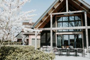 ein Haus mit einem Tisch und Stühlen davor in der Unterkunft Glundr! in Behelp