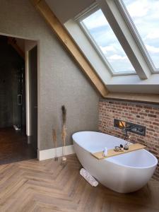 a bath tub in a bathroom with a skylight at Glundr! in Behelp