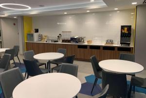 a classroom with white tables and chairs and a kitchen at Microtel Inn & Suites by Wyndham Rehoboth Beach in Rehoboth Beach