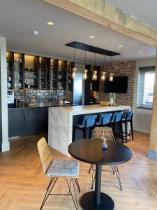 a kitchen with a bar with chairs and a table at Glundr! in Behelp