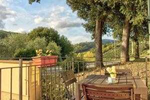 einen Holztisch mit zwei Stühlen und einem Zaun in der Unterkunft Casa Cornelia in Lucolena in Chianti