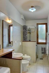 ein Badezimmer mit Toilette, Waschbecken und Spiegel in der Unterkunft Casa Cornelia in Lucolena in Chianti