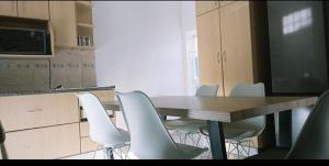 a conference room with a wooden table and white chairs at Blue Nile Guest in Cape Town