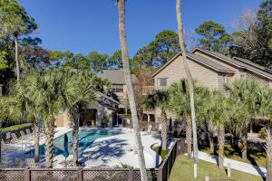 una casa con palmeras frente a una piscina en 21 Moorings, en Hilton Head Island