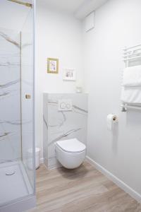 y baño blanco con aseo y ducha. en Space Apartments Old Town - River View, en Szczecin