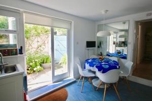 a dining room with a table and white chairs at Captains Cottage in Deal