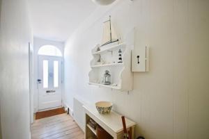 a kitchen with white walls and a wooden table at Captains Cottage in Deal +33 photos
