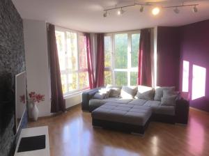 - un salon avec un canapé et quelques fenêtres dans l'établissement 4 Zimmer Wohnung mit 6 Betten nahe Hamburg, à Glinde