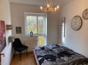 a bedroom with a bed and a clock and a chair at 4 Zimmer Wohnung mit 6 Betten nahe Hamburg in Glinde