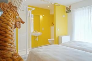 a bedroom with a bed and a bathroom with a horse head at Gîte du Jardin in Theux +52 photos