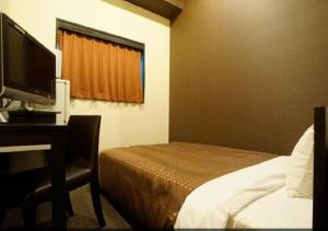 Postel nebo postele na pokoji v ubytování HOTEL LiVEMAX Osaka Namba