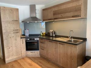 kuchnia z drewnianymi szafkami i zlewem w obiekcie Pom Pom, 3 bedroom apt with stunning mountain views-Samoëns w mieście Samoëns