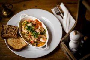 un plato blanco con un tazón de sopa de camarones y tostadas en Gościniec pod Zającem en Oleśnica