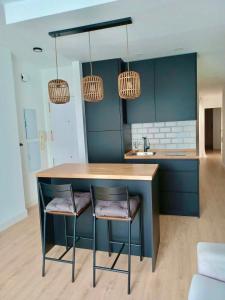 a kitchen with two bar stools and two lights at La Plaza Apartamento Armilla in Armilla
