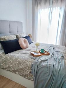 a bed with a tray on it with a table on it at La Plaza Apartamento Armilla in Armilla