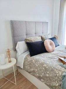 a bed with pillows on it in a bedroom at La Plaza Apartamento Armilla in Armilla