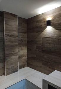 a bathroom with a shower with a wooden wall at Bello Monoambiente ZV212, Edif Zetta Village Airport in Colonia Mariano Roque Alonso
