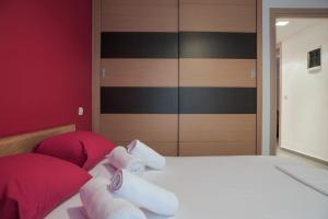 1 dormitorio con 1 cama con almohadas rojas y blancas en 5 min from Papageorgiou Free Indoor Parking en Tesalónica