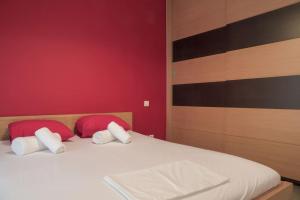 een slaapkamer met een bed met twee rode en witte kussens bij 5 min from Papageorgiou Free Indoor Parking in Thessaloniki