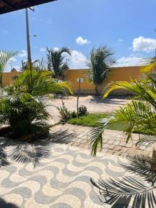 a courtyard with palm trees and a building at Casa 2 Gold Star Village in Majorlândia