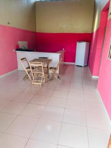 Casa 2 Gold Star Village في ماغورلانديا: غرفة مع طاولة وكراسي وجدار وردي