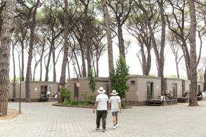 two men walking down a brick walkway in front of a tiny house at Fabulous village in Casal Palocco