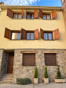 un edificio con puertas y ventanas marrones en Cal Cuaresma en Isona