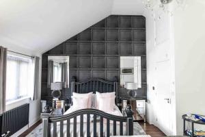 a bedroom with a large bed with a black wall at Open plan Stylish Apartment in rural Kent in Kent