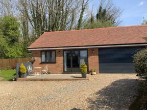 a small brick house with a garage at Open plan Stylish Apartment in rural Kent in Kent