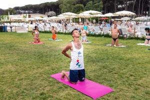 a young boy is standing on a pink yoga mat at Fabulous village in Casal Palocco