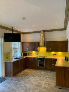a large kitchen with wooden cabinets and a large window at Owlswood Apartments in Edinbane