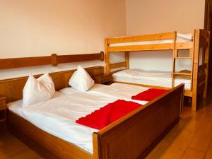 1 Schlafzimmer mit 2 Etagenbetten mit roter Bettwäsche in der Unterkunft Pension Gartner in Wallern im Burgenland