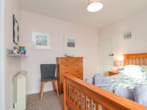 a bedroom with a bed and a desk and a chair at By-sea in Marazion