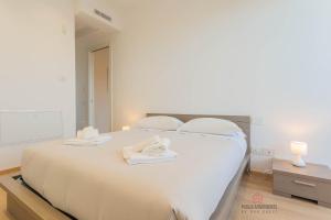 a bedroom with a large white bed with towels on it at Casa 7 Mari - BARI Fiera del Levante - Puglia Apartments in Bari