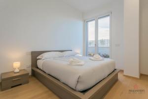 a bedroom with a large bed with a large window at Casa 7 Mari - BARI Fiera del Levante - Puglia Apartments in Bari