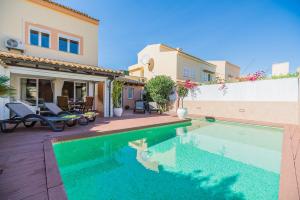 a swimming pool in front of a house at Sa Marina in Alcudia