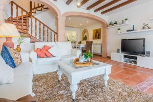 a living room with white furniture and a tv at Sa Marina in Alcudia