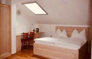 1 dormitorio con cama, escritorio y ventana en Pension Gartner, en Wallern im Burgenland