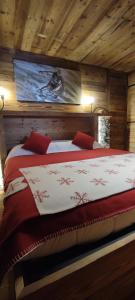 a bedroom with a bed in a wooden cabin at La Maison Derby in La Salle